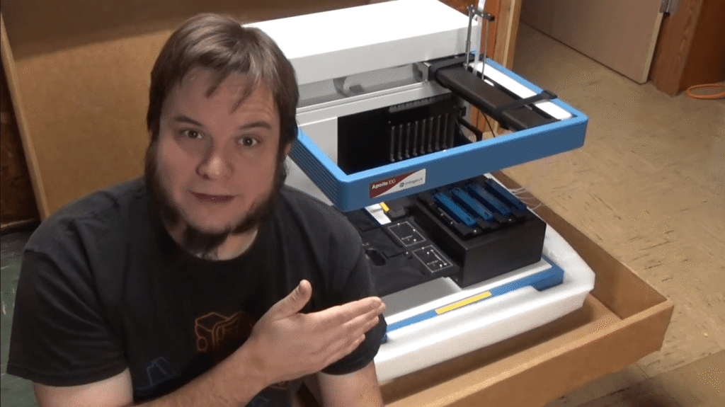 Person demonstrating a DNA sequencing machine in a home laboratory setting